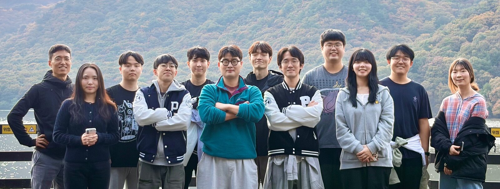 Lee Optimization Group members together outdoors by a lake in autumn